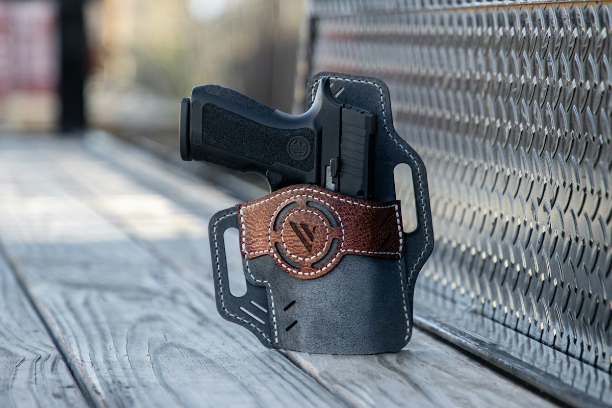 Handgun in Kydex Concealment Holster on Shooting Range Bench with Targets